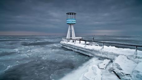Frozen Lighthouse by the Icy Sea Shore wallpaper