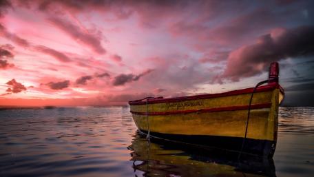 Serene Sunset with Yellow Boat in Pink Sky wallpaper