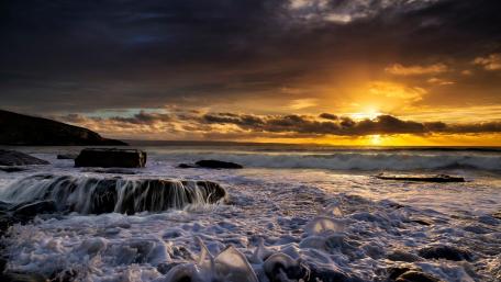 Serene Sunset Over the Foamy Waves wallpaper