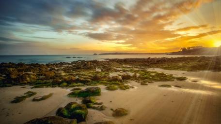 Sunset Serenity Over Rocky Shoreline wallpaper