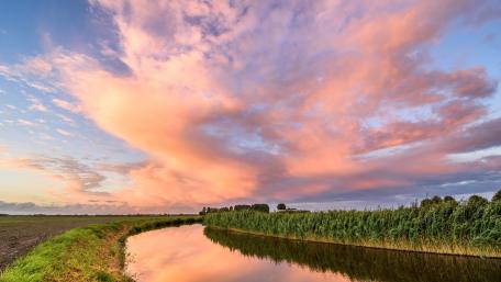 Majestic Evening Sky Over Tranquil Canal wallpaper