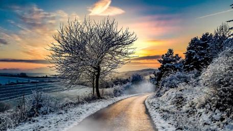 Winter Road Through a Snowy Landscape at Sunset wallpaper