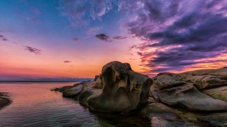 Vibrant Purple Sunset Over Serene Sea Rocks wallpaper