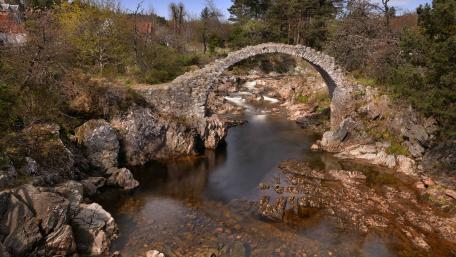 Serene Stone Bridge Over Tranquil River Scene wallpaper