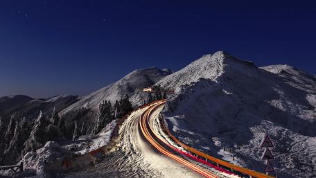 Winter Night Road Through Mountains wallpaper