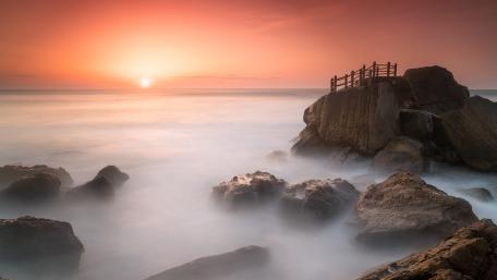 Serene Misty Sunrise Over Rocky Horizon wallpaper