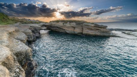 Serene Cliffside Sunrise Over Turquoise Sea wallpaper