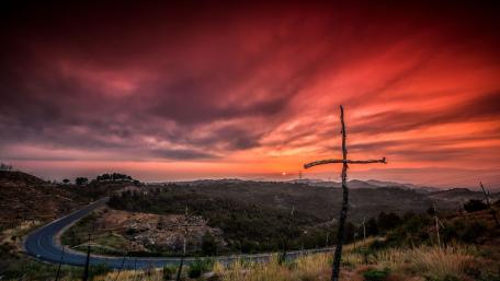 Serene Sunset Over Curved Road and Cross wallpaper