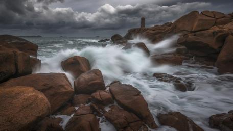 Mysterious Lighthouse Amidst Turbulent Waves wallpaper
