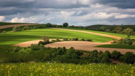 Serene Hillside Landscape Over Rolling Fields wallpaper