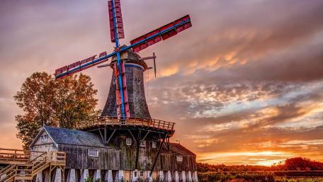 Serene Sunset Over a Rustic Windmill Scene wallpaper