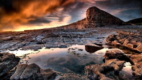 Majestic Rock Formation by Serene Puddle at Sunset wallpaper