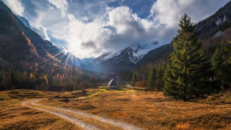 Serene Mountain Village Under Sunlight Rays wallpaper