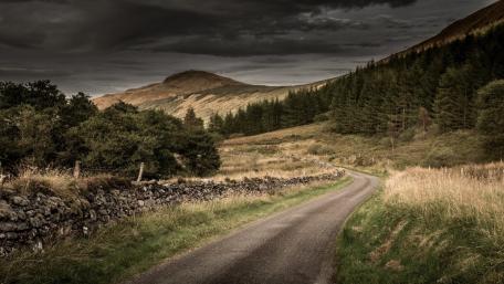 Winding Road Through Serene Landscape wallpaper