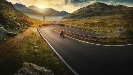Curving Road Through Majestic Mountains wallpaper
