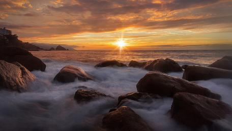 Serene Sunset Over the Rocky Shoreline wallpaper