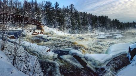 Winter Serenity Over Frozen River and Bridge wallpaper