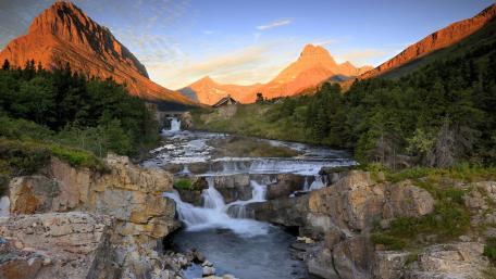 Majestic Waterfall Amidst Serene Mountains wallpaper