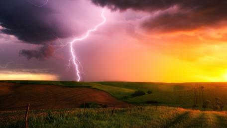 Majestic Thunderstorm Over Rolling Hills wallpaper