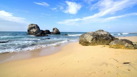 Tranquil Beach with Boulders and Gentle Waves wallpaper