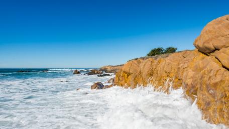 Serene Coastal Beauty Under Bright Blue Skies wallpaper