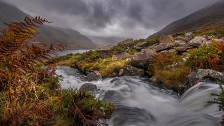 Majestic River Flowing Through Mountainous Landscape wallpaper