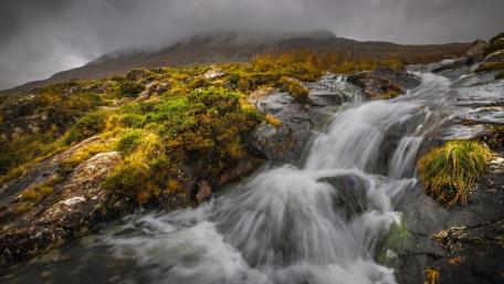 Majestic Waterfall in a Cloudy Landscape wallpaper