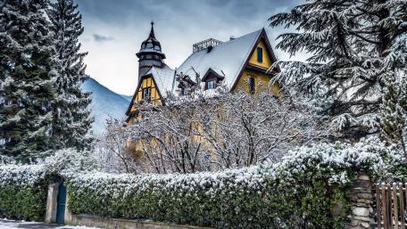 Charming Winter Cottage Amidst Snowy Landscape wallpaper