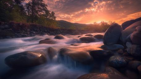 Serene Sunset Over Flowing River wallpaper