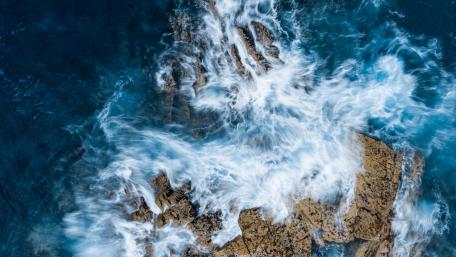 Waves against rocks wallpaper