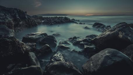 Serene Twilight Over Rocky Shoreline wallpaper