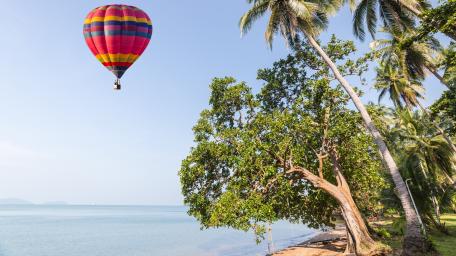 Colorful Hot Air Balloon Over Serene Shoreline wallpaper