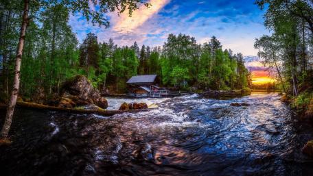 Tranquil Cottage by the River Under Sunset Sky wallpaper