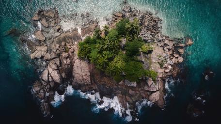 Serene Islet Surrounded by Turquoise Waves wallpaper