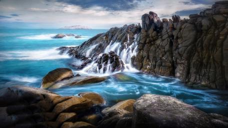 Majestic Waterfall Cascading Over Rocks wallpaper