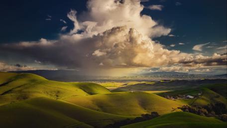 Green Hills in Majestic Cloudy Skies wallpaper
