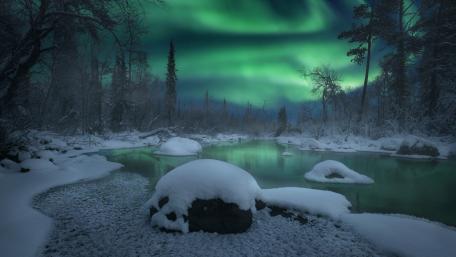 Majestic Aurora Borealis Over a Winter River wallpaper