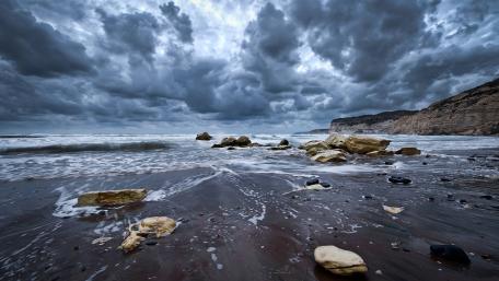 Dramatic Clouds Over Serene Coastal Shores wallpaper