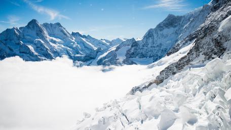 Majestic Winter Peaks Enveloped in Clouds wallpaper