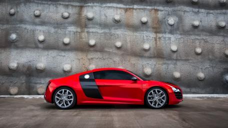 Sleek Red Audi R8 Against Textured Wall wallpaper