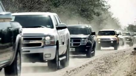 Convoy of Powerful Pickup Trucks on a Dusty Road wallpaper