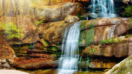 Serene Waterfall Amidst Autumn Colors wallpaper