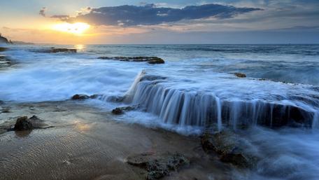 Tranquil Ocean Sunset with Scattered Clouds wallpaper