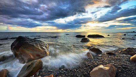 Serene Sunset Over Rocky Seashore wallpaper