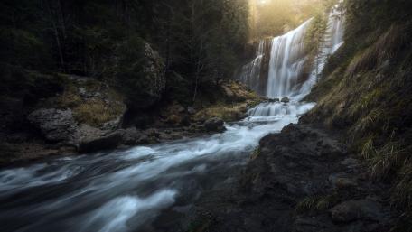 Majestic Waterfall in Serene Forest Setting wallpaper