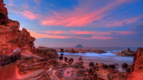 Majestic Sunset Over Rocky Shoreline wallpaper