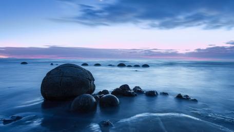 Serene Blue Hour Over Ocean Boulders wallpaper