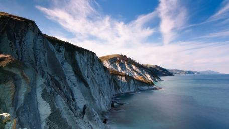 Stunning Coastal Cliffs Under a Blue Sky wallpaper