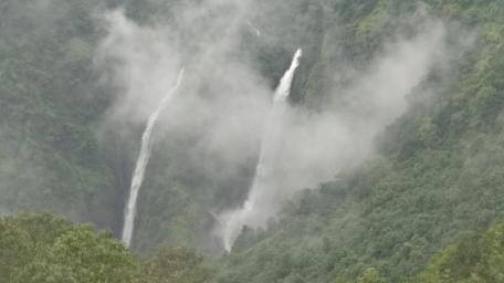 Majestic Waterfalls Surrounded by Misty Mountains wallpaper