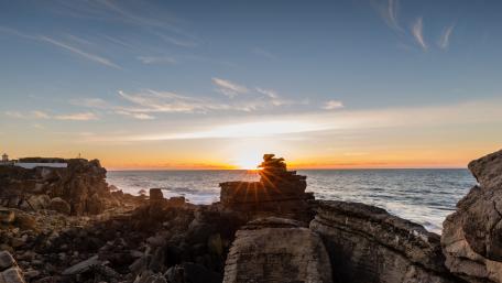 Serene Stone Balancing at Sunset Over the Horizon wallpaper